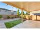 A cozy backyard featuring a covered patio, artificial turf, brick accents, and manicured landscaping, perfect for outdoor living at 8930 W Ford Ave, Las Vegas, NV 89148