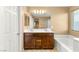 Bathroom with double sink vanity, a large mirror, and a bathtub at 8930 W Ford Ave, Las Vegas, NV 89148