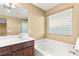 Bathroom vanity with double sinks next to the tub and window at 8930 W Ford Ave, Las Vegas, NV 89148