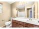 Bathroom featuring a single sink with dark cabinets, white toilet, and a large mirror at 8930 W Ford Ave, Las Vegas, NV 89148