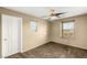 Bedroom with neutral walls, carpet, two windows, ceiling fan, and a white door at 8930 W Ford Ave, Las Vegas, NV 89148