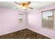 Bedroom featuring pink walls, two windows with blinds, carpet, and a ceiling fan at 8930 W Ford Ave, Las Vegas, NV 89148