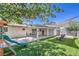 Expansive backyard with covered patio, grassy area, mature tree, and a playset at 905 Smith St, Las Vegas, NV 89108