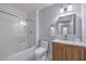Clean bathroom with updated vanity, shower over tub with sliding glass door, and checkered floors at 905 Smith St, Las Vegas, NV 89108