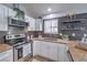 Well-lit kitchen with stainless steel appliances, granite countertops, and tile backsplash at 905 Smith St, Las Vegas, NV 89108