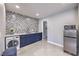 This laundry room features designer backsplash, modern washer and dryer, and blue cabinets at 905 Smith St, Las Vegas, NV 89108
