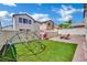 Well-maintained backyard with lush artificial grass, a patio area, and a playground at 9131 Grand Sunburst Ct, Las Vegas, NV 89149