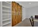 Rustic barn doors next to custom built-in shelving in dining area at 9131 Grand Sunburst Ct, Las Vegas, NV 89149