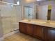 Bathroom featuring a double sink vanity with wood cabinets and a glass shower at 9321 Lady Finger Ct, Las Vegas, NV 89149