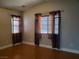 Bright bedroom with two windows, neutral walls, and wood-look flooring at 9321 Lady Finger Ct, Las Vegas, NV 89149