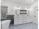 Stylish bathroom featuring double vanity, modern fixtures, and soaking tub with blue patterned tile flooring at 9612 Glengarry Dr, Las Vegas, NV 89129