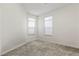 Bright, carpeted bedroom with neutral walls and two windows providing natural light at 9612 Glengarry Dr, Las Vegas, NV 89129