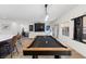 Well-lit game room with a pool table and stylish cue rack, adjacent to the living area with backyard views at 9612 Glengarry Dr, Las Vegas, NV 89129