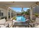 Relax on the covered patio with a view of the pool, rock waterfall, and lush landscaping at 9612 Glengarry Dr, Las Vegas, NV 89129