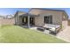 Cozy backyard featuring a covered patio, stylish seating, and a well-manicured lawn at 9785 Granite Mesa St, Las Vegas, NV 89141