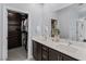 Modern bathroom with a dual sink vanity, framed mirror, and a walk-in closet at 9785 Granite Mesa St, Las Vegas, NV 89141