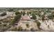 This aerial captures a desert home equipped with solar panels and a long driveway leading to an open carport at 1050 Morgan Ln, Pahrump, NV 89060