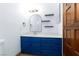 Vanity in bathroom featuring a blue cabinet with white countertop, a mirror, and shelving at 1050 Morgan Ln, Pahrump, NV 89060