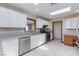 Modern kitchen featuring stainless steel appliances, white cabinets, and bright skylights above at 1050 Morgan Ln, Pahrump, NV 89060