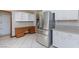 Modern kitchen boasting stainless steel fridge, white cabinets, and tile floors with a desk at 1050 Morgan Ln, Pahrump, NV 89060