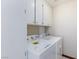 Dedicated laundry room showcasing modern washer and dryer units and built-in storage cabinets at 1050 Morgan Ln, Pahrump, NV 89060