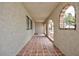 Covered outdoor patio featuring clay tile flooring, stucco walls, and arched windows at 1050 Morgan Ln, Pahrump, NV 89060
