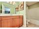 Bathroom with painted light-green walls, a wood vanity, tile floor, tub and toilet at 10725 Wrigley Field Ave, Las Vegas, NV 89166