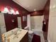 Bathroom showcasing a shower over tub, a vanity with sink, and deep-toned red walls at 10725 Wrigley Field Ave, Las Vegas, NV 89166