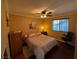 Cozy bedroom with a ceiling fan, a window with blinds, and dark wood-look floors at 10725 Wrigley Field Ave, Las Vegas, NV 89166