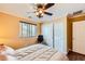 Bedroom with tan walls, crown molding, a ceiling fan, window, and a bed facing sliding-door closets at 10725 Wrigley Field Ave, Las Vegas, NV 89166