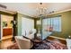 Olive-green dining room with chandelier, hardwood floors and patterned rug, plus view to a nearby bathroom at 10725 Wrigley Field Ave, Las Vegas, NV 89166