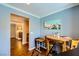 Dining area with wood floors and serene blue walls shows access to kitchen and living at 10725 Wrigley Field Ave, Las Vegas, NV 89166