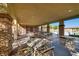 Outdoor patio with multiple tables and chairs under a shaded structure with stone columns at 10725 Wrigley Field Ave, Las Vegas, NV 89166