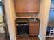 A modern wet bar with wood cabinets, granite counters and a wine fridge at 10725 Wrigley Field Ave, Las Vegas, NV 89166