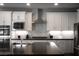 Modern kitchen featuring white cabinets, stainless steel appliances, and gray backsplash at 12495 Point Sierra St, Las Vegas, NV 89138