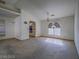 Open living room featuring decorative archway to kitchen, a ceiling fan, and bright window at 1409 Santa Margarita St # G, Las Vegas, NV 89146