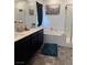 Bathroom featuring a soaking tub, a glass shower, a double vanity, and black cabinets at 1618 Dakota Group Ave, North Las Vegas, NV 89084