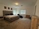 Bedroom featuring carpet, a cushioned headboard bed, an upholstered chaise, and bright windows at 1618 Dakota Group Ave, North Las Vegas, NV 89084