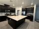 Spacious kitchen with an island, dark cabinets, stainless steel appliances, and tiled backsplash at 1618 Dakota Group Ave, North Las Vegas, NV 89084