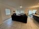 Spacious living room featuring tile flooring, bright windows, and a dark sectional sofa at 1618 Dakota Group Ave, North Las Vegas, NV 89084