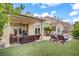 This backyard features a covered patio, comfortable seating, manicured lawn and a tranquil pool area at 2010 Catalina Marie Ave, Henderson, NV 89074