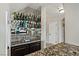 Stylish bar area featuring granite countertops, a sink, mirrored backsplash and glass shelving at 2010 Catalina Marie Ave, Henderson, NV 89074