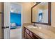 Bathroom with granite countertop vanity, wood cabinets and a view into the blue bedroom at 2010 Catalina Marie Ave, Henderson, NV 89074