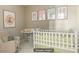 A cozy Bedroom with a crib, changing table, soft-colored decor, and a comfortable armchair at 2010 Catalina Marie Ave, Henderson, NV 89074