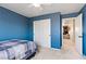Carpeted bedroom features blue accent wall and sliding door closet at 2010 Catalina Marie Ave, Henderson, NV 89074