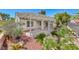 Beautiful backyard featuring a covered patio, lovely landscaping with rock and cacti, and bright floral features at 2154 Idaho Falls Dr, Henderson, NV 89044