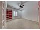 This bedroom offers great space, neutral carpet and a ceiling fan, built-in shelving, and great natural light at 2154 Idaho Falls Dr, Henderson, NV 89044