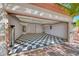Spacious garage with black and white checkered flooring with extra shelving and overhead lighting at 2154 Idaho Falls Dr, Henderson, NV 89044