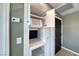 Hallway features a microwave in built-in cabinets next to a dark wooden door, offering convenience at 2154 Idaho Falls Dr, Henderson, NV 89044
