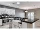 Well-appointed kitchen with stainless steel appliances, a farmhouse sink, and black countertops at 2154 Idaho Falls Dr, Henderson, NV 89044